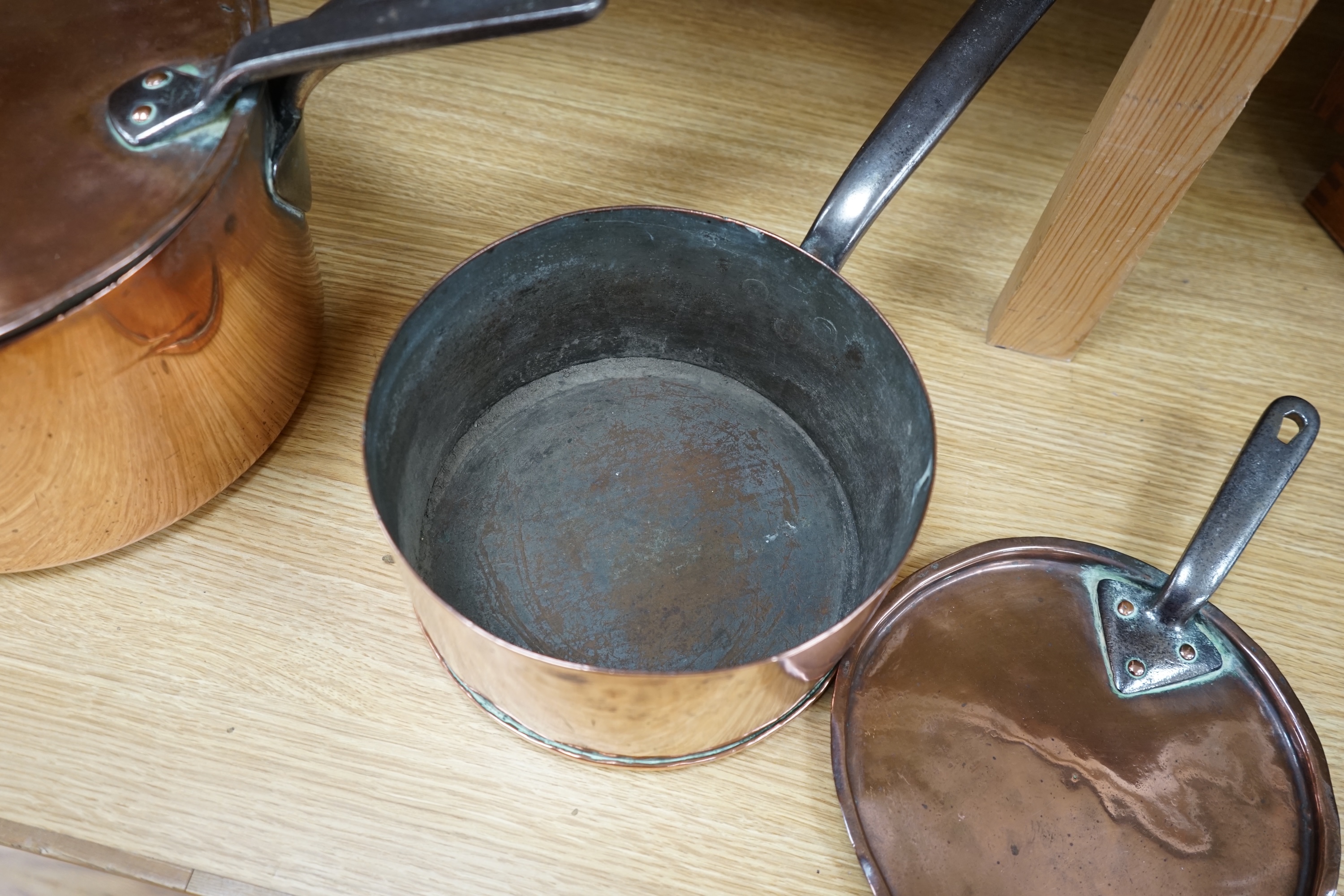 Two 19th century graduated copper and wrought iron saucepans and covers. Condition - fair to good